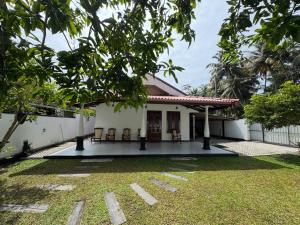 a house with a yard with chairs in front of it at Thousand Sunny Villa in Duwegoda
