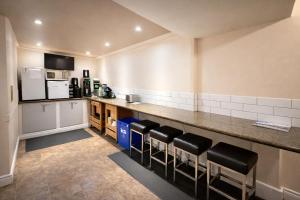 a kitchen with a counter and some black stools at Rychter Hotel Hope in Hope