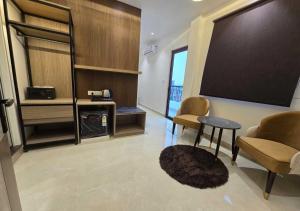 a living room with a flat screen tv and a table at HOTEL AYUSHMAN in Varanasi