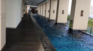 a hallway of a building with a pool of water at Prestige Living at B Residence BSD in Serpong