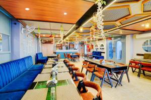 a restaurant with tables and chairs and blue booths at Collection O Kotdwar Railway Junction Formerly K Square in Kotdwāra