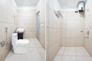 a bathroom with a toilet and a glass shower at Collection O Kotdwar Railway Junction Formerly K Square in Kotdwāra