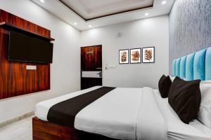 a bedroom with a bed and a flat screen tv at Collection O Kotdwar Railway Junction Formerly K Square in Kotdwāra
