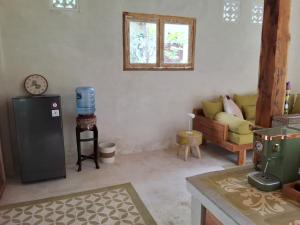 a living room with a refrigerator and a couch at Kelapa Cottage in Amed