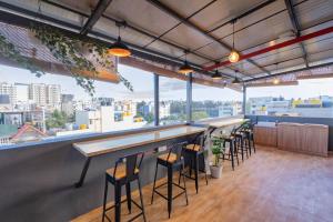 a bar with stools in a room with a view at Loop by Zolo HSR Layout, Bangalore in Bangalore