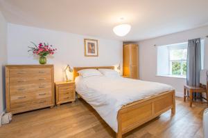 a bedroom with a bed and a dresser and a window at Ty Top in Newport