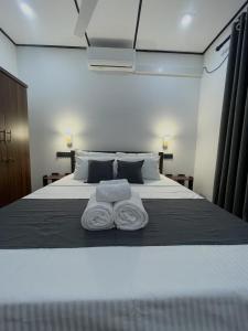 a bedroom with a bed with two towels on it at Thousand Sunny Villa in Duwegoda