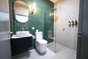 a bathroom with a toilet and a sink and a mirror at Belmore Hotel Maitland in Maitland +18 photos