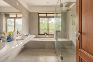 a bathroom with a tub and a sink and a shower at ELIVAAS Signature Casa Verdea 4-BHK Villa With Private Pool & Lift Near Popular Restaurants in Siolim