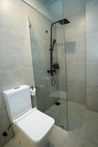 a bathroom with a toilet and a glass shower at Stay Ceylon - Weligama in Weligama
