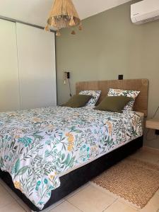 a bedroom with a bed with a colorful comforter at Le Ravintsara in Saint-André