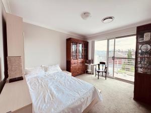 a bedroom with a bed and a large window at A Zen Tea Sanctuary in Australia in Schofields +2 photos