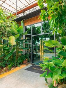 a building with a large glass door with plants at Tavana Residence in Ban Na Bon