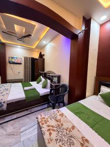 a hotel room with three beds and a chair at Guru Amrit Residency & Guru Kripa Guest house in Ayodhya