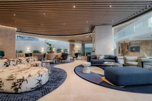 a hotel lobby with a couch and tables and chairs at Hyatt Regency Malta in St. Julianʼs +90 photos