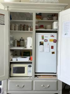 an open refrigerator with a microwave in it at Incredible Views! Luxurious Studio & Outdoor Living in Wellington