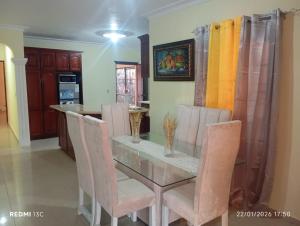 a dining room with a glass table and chairs at Casa vacanza, Mendosa in Bayaguana +9 photos
