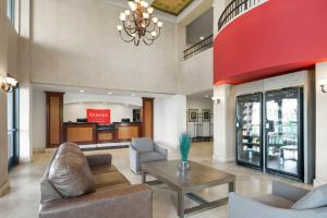 a lobby with a couch and chairs and a table at Ramada Suites by Wyndham San Diego Hotel Circle Area in San Diego