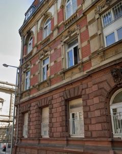 a brick building with many windows on a street at WKI Company in Mannheim