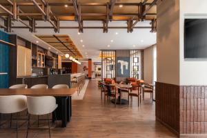 a restaurant with tables and chairs and a bar at Hyatt Place Merida/ Via Montejo in Mérida