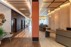 an office lobby with a hallway with a desk and chairs at Hyatt Place Merida/ Via Montejo in Mérida +148 photos