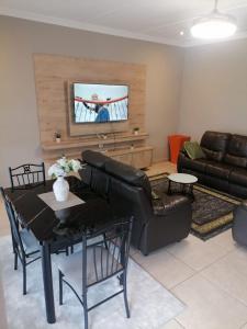 a living room with a couch and a table at Elegant guest house in Matsapha +11 photos