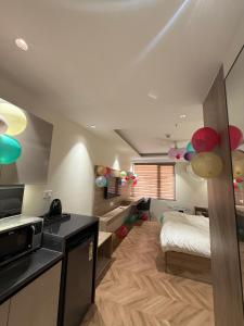 a bedroom with a bed and a kitchen with balloons at Cozy haven in Greater Noida