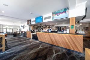 a restaurant with a bar with a tv above it at Belmore Hotel Maitland in Maitland