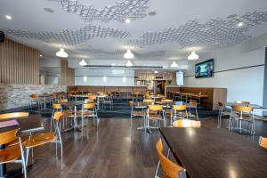 a dining room with tables and chairs in a restaurant at Belmore Hotel Maitland in Maitland