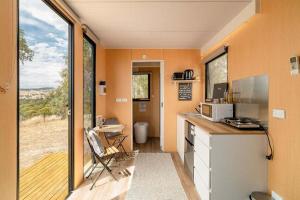 a tiny house with a kitchen and a desk with a window at Hill View at Euroa by Tiny Away in Euroa