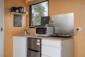 a kitchen with a counter with a microwave and a window at Hill View at Euroa by Tiny Away in Euroa