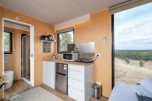 a kitchen with a counter with a microwave and a window at Hill View at Euroa by Tiny Away in Euroa