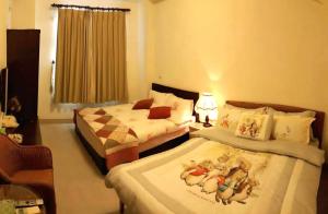 a bedroom with two beds and a lamp and a window at 水悅雅築民宿 Shuiyue Guest House in Hualien City +53 photos