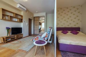 a bedroom with a bed and a living room at Granus apartments in Druskininkai