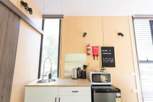 a small kitchen with a sink and a microwave at Organic Farm Stay by Tiny Away in Numurkah