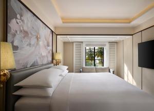 a bedroom with a large white bed and a window at Renaissance Goa Hotel in Goa