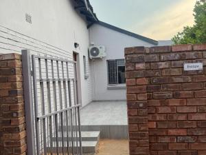 a brick fence in front of a house at Soliha Guesthouse in Trichardt