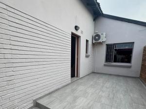 a white building with a door and a window at Soliha Guesthouse in Trichardt