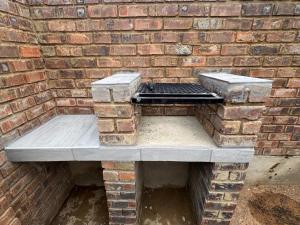 a brick wall with a grill in front of a brick wall at Soliha Guesthouse in Trichardt