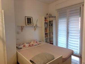 a bed in a room with a book shelf at Milan nanna B&B, metro M3,IEO, Duomo COLAZIONE INCLUSA in San Donato Milanese