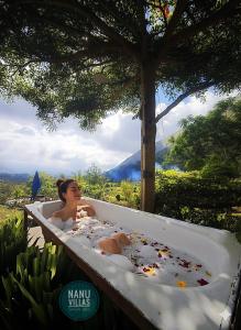 a woman laying in a bathtub covered in debris at Sada 360 Nanu Homestay in Sembalun Lawang