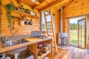 a kitchen with a sink in a wooden cabin at Deep Creek Sunset by Tiny Away in Romsey