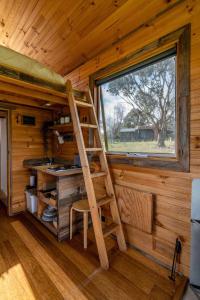 a ladder in a kitchen in a log cabin at Deep Creek Sunset by Tiny Away in Romsey