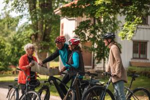 a group of people with bikes and a man holding a map at Vandrarhemmet Årås Säteri och Trädgårdar in Årås