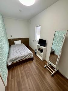 ein Schlafzimmer mit einem Bett und einem Spiegel in der Unterkunft Lodges大黒 in Toyama