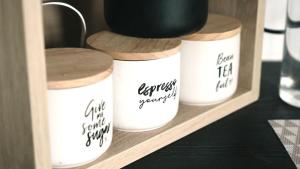 four white mason jars sitting on a shelf at Raintree Farmstay by Tiny Away in Sarsfield