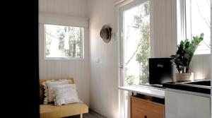 a kitchen with a window and a chair next to a counter at Raintree Farmstay by Tiny Away in Sarsfield