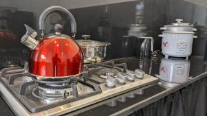 a red tea kettle sitting on top of a stove at Breeze house in Tangalle