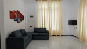 a living room with a couch and a tv at Breeze house in Tangalle