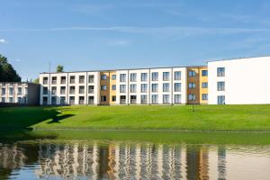 a building next to a body of water at Błażejewko Resort in Błażejewko